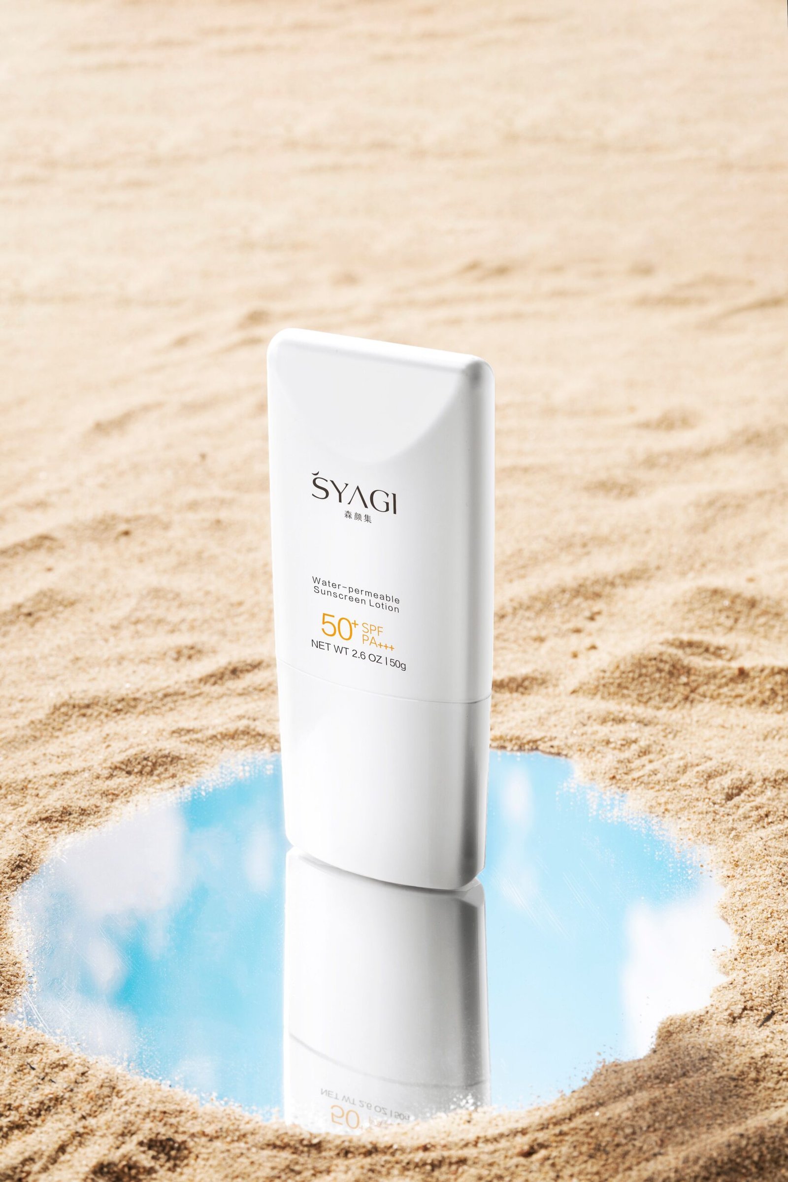 Sunscreen bottle with SPF 50 placed on sand with a mirror reflecting blue sky, ideal for summer skincare promotions.
